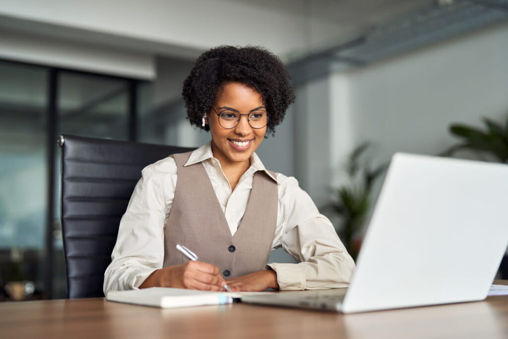 Mulher estudando em um notebook sobre as 4 etapas do processo de gestão do conhecimento