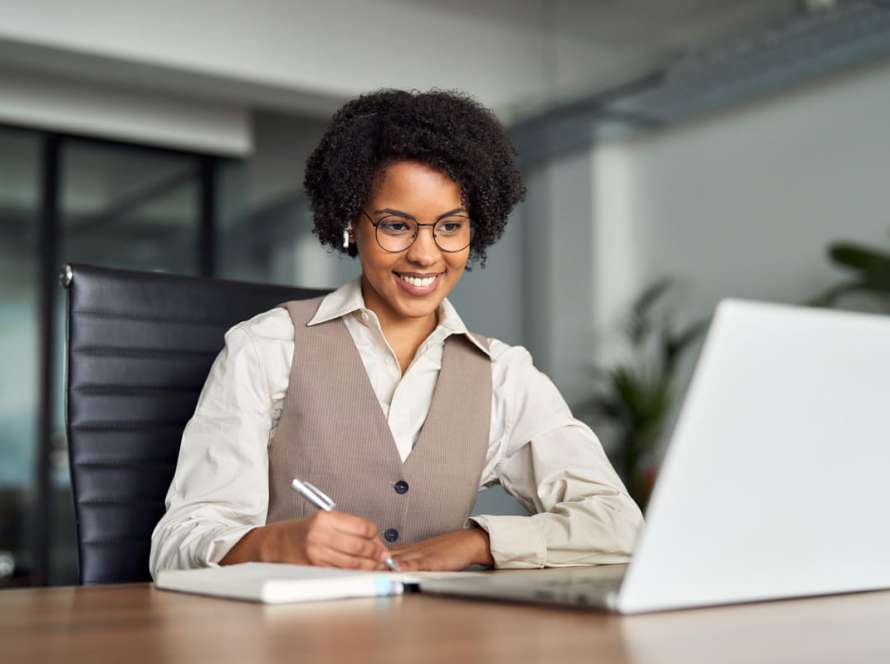 Mulher estudando em um notebook sobre as 4 etapas do processo de gestão do conhecimento