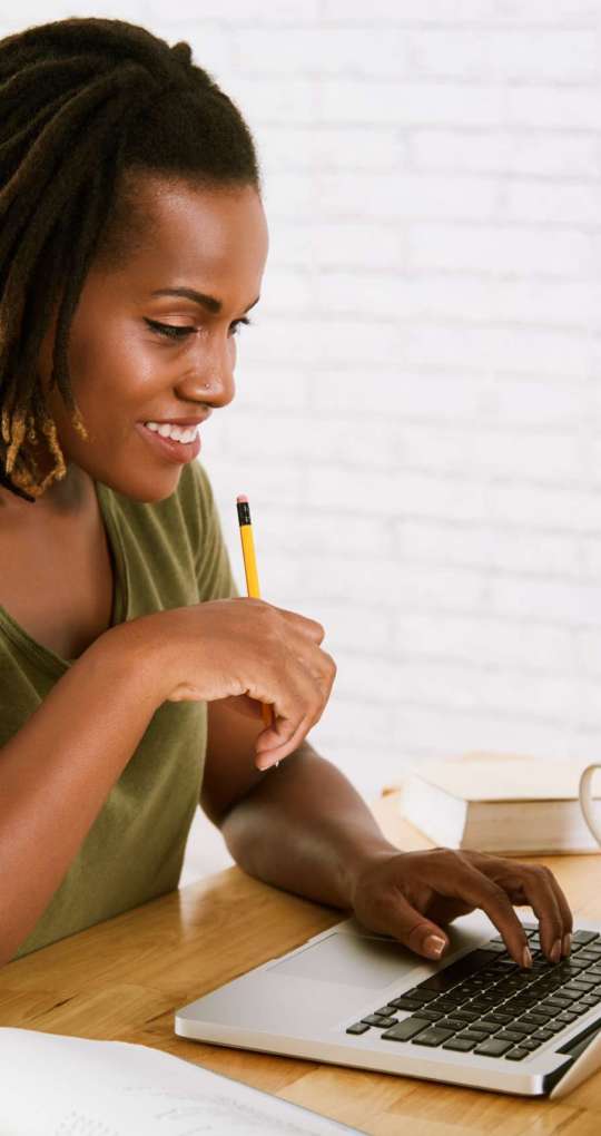 Pretty young Black woman studying at home